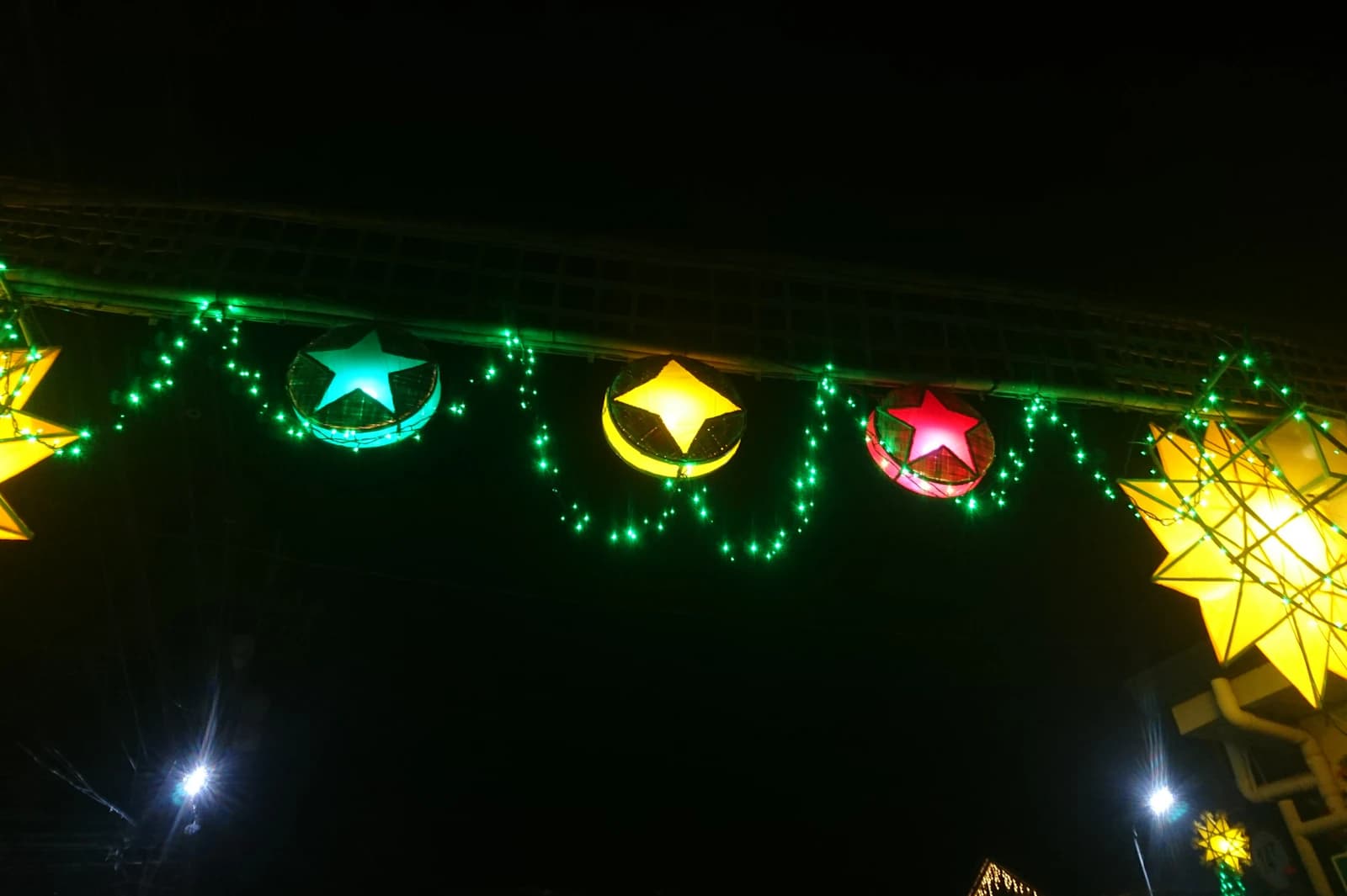 Colourful star lanterns and green lights at night.