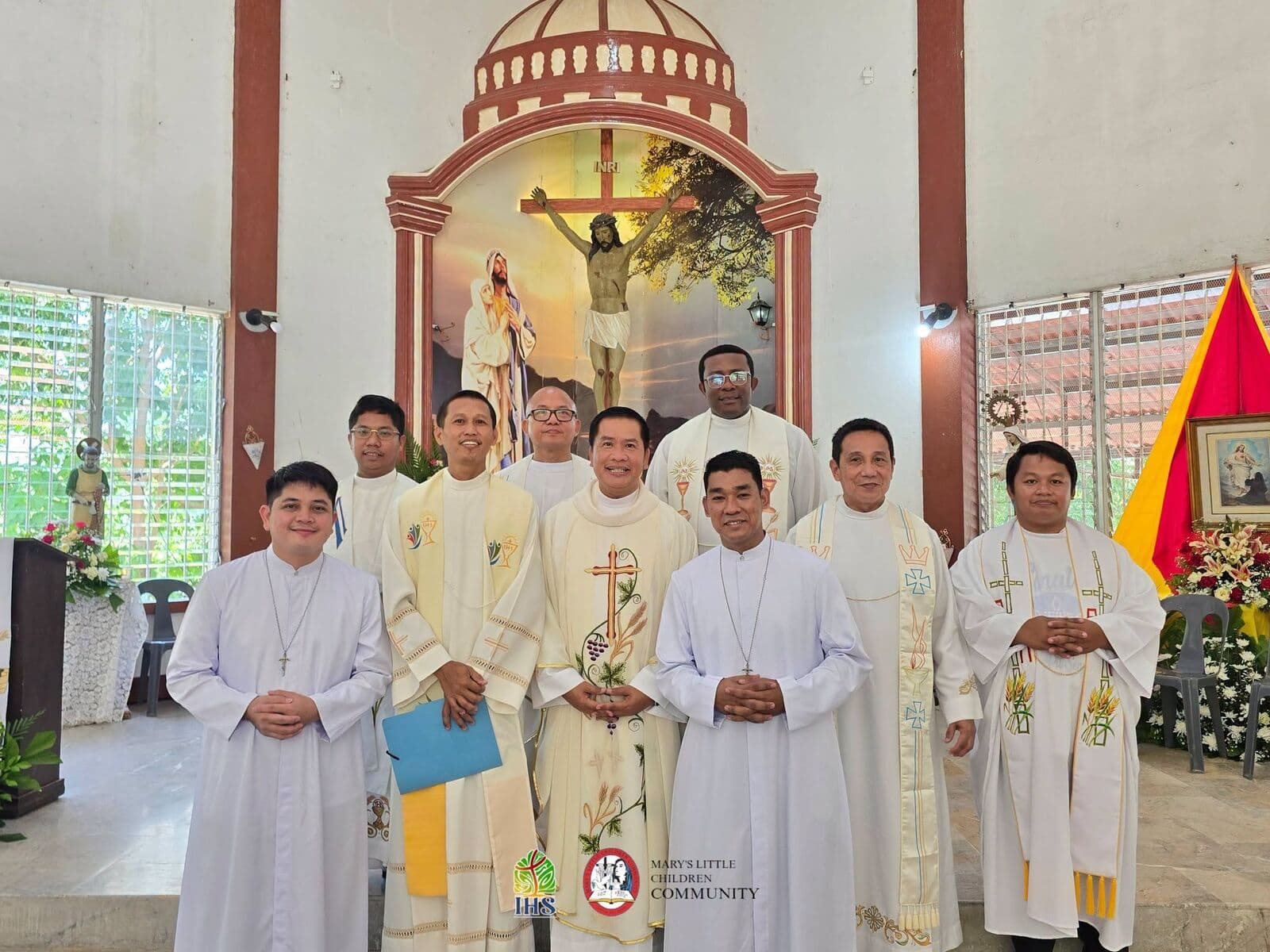 Priests and brothers of the Community in white vestments, standing together before the altar