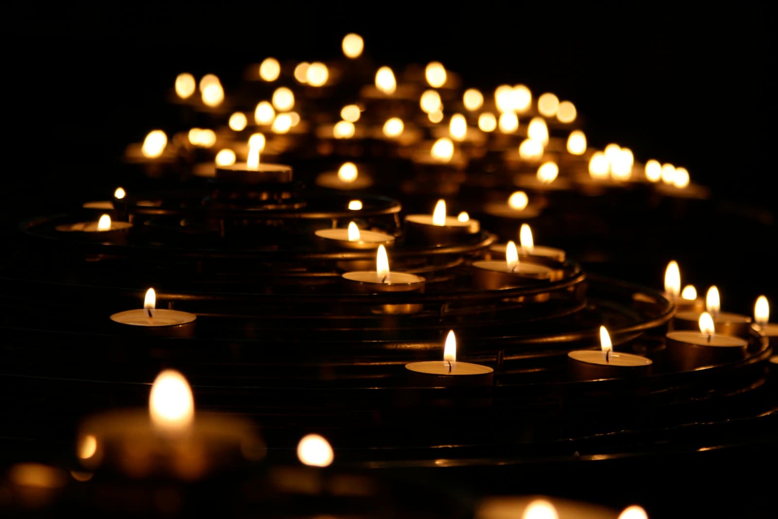 Rows of lit candles seen from below.
